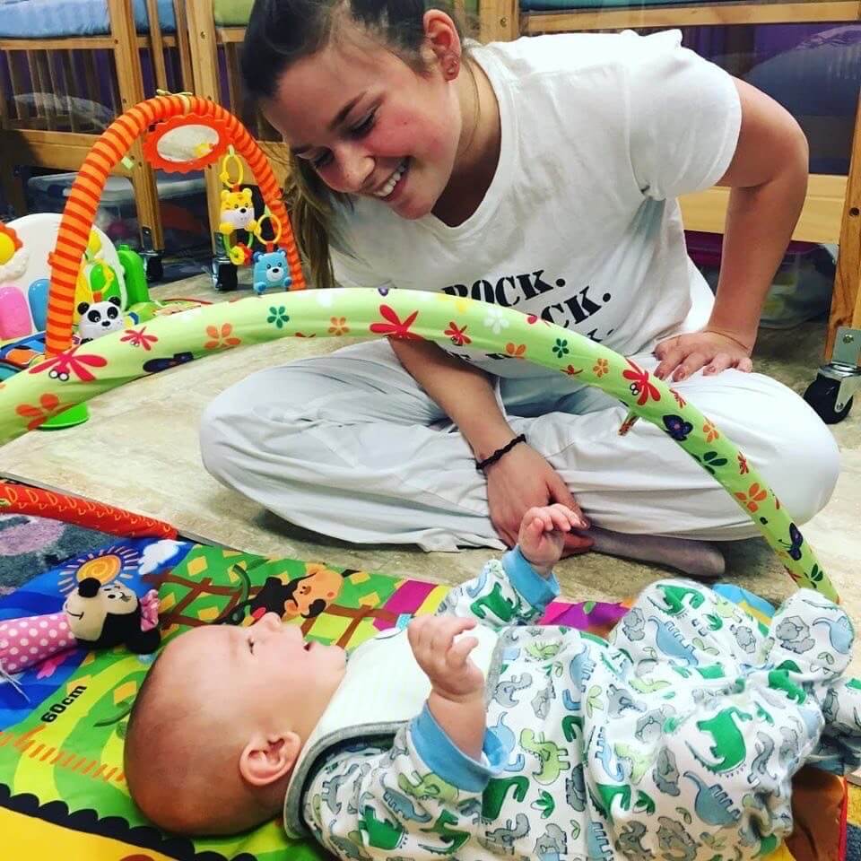 A baby smiling with her mother