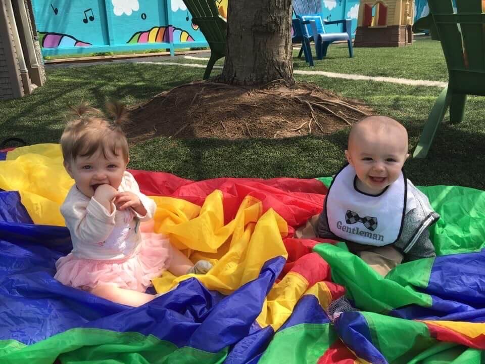 Two babies smiling in the tent