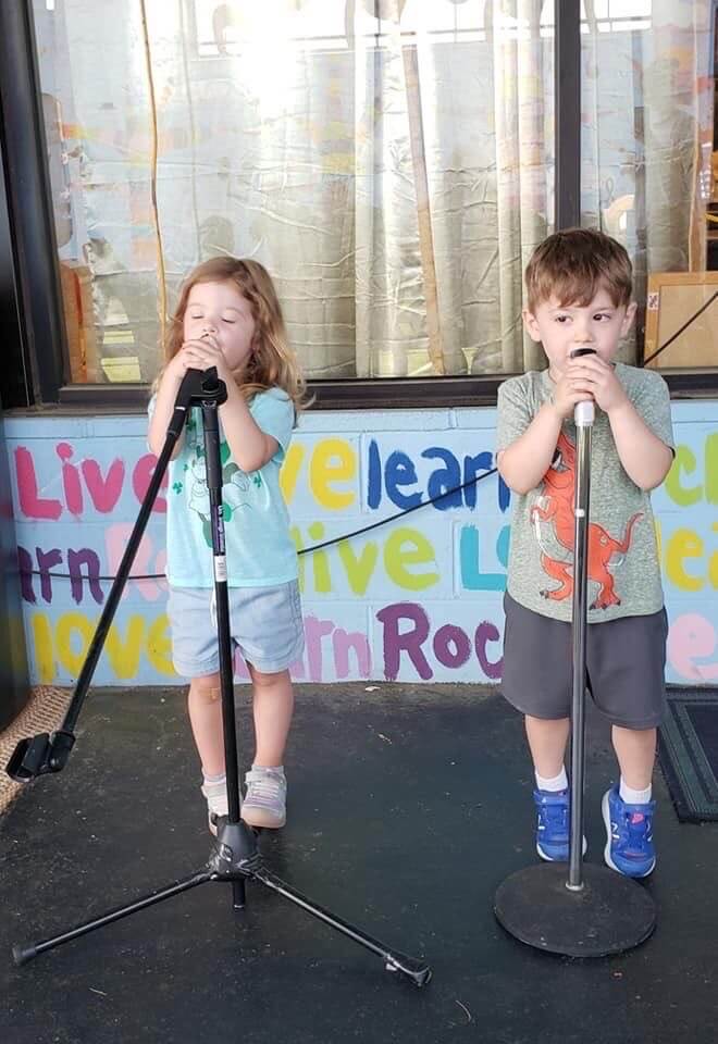 Two kids singing on stage at our music preschool in Owings Mills