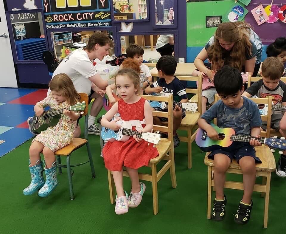 Children playing small musical instruments