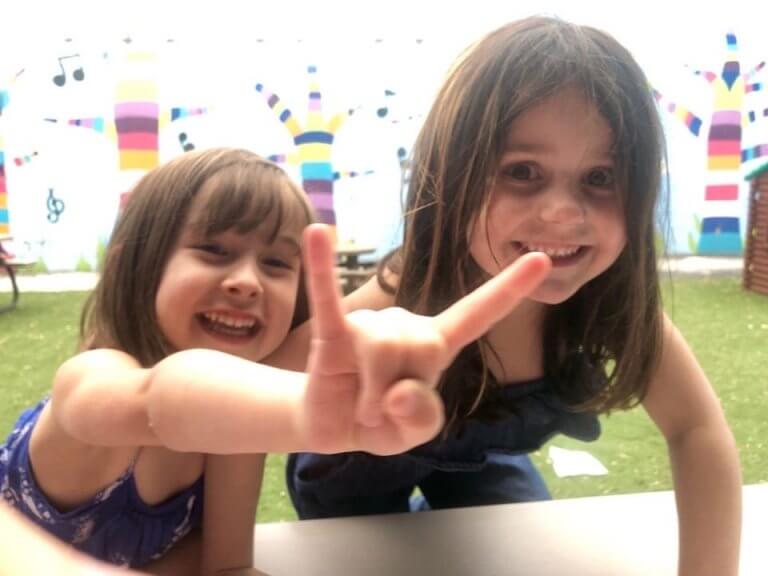 Two girls having fun and smiling. Visit our preschool in Owings Mills, Maryland.