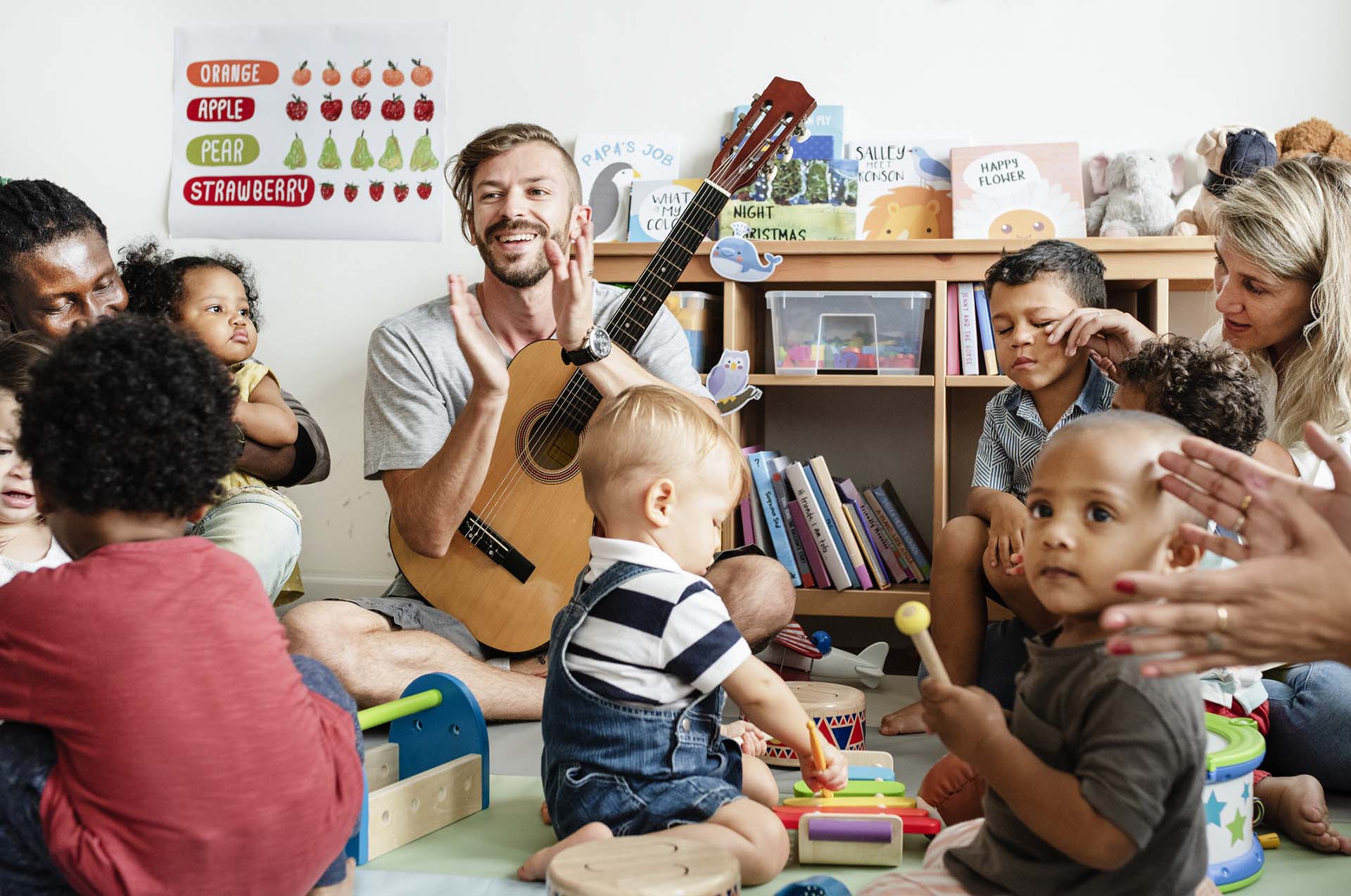 Children playing music in classroom with teacher