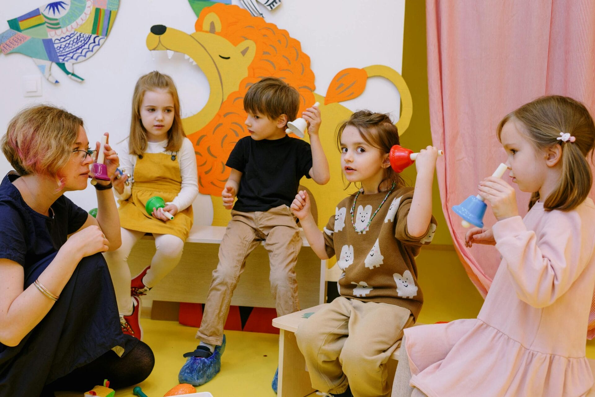 Young children playing musical bells with a teacher — music preschool Owings Mills at Drool of Rock