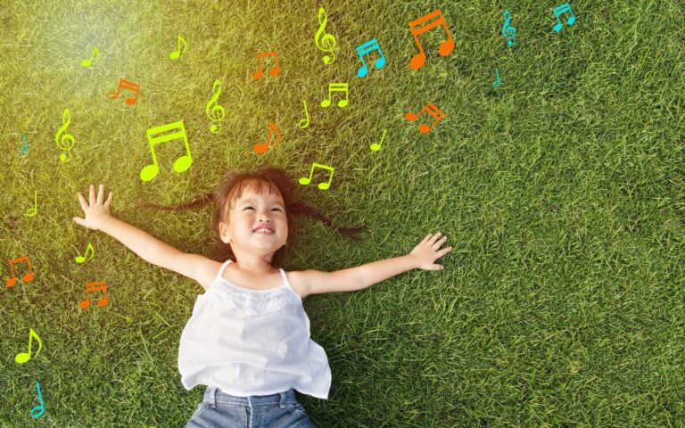 Music and Early Language Development. Child playing with musical notes outdoors